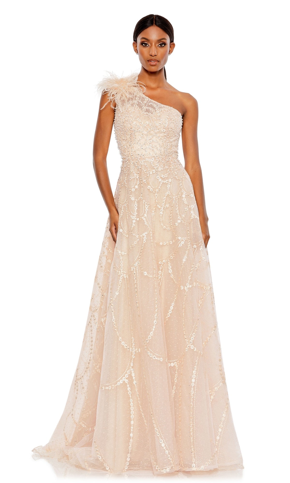 A woman wears the Beaded One-Shoulder Prom Gown: Mac Duggal 20389—a light beige, sequin and bead-embellished formal dress with feather detail on the shoulder—standing against a white background.